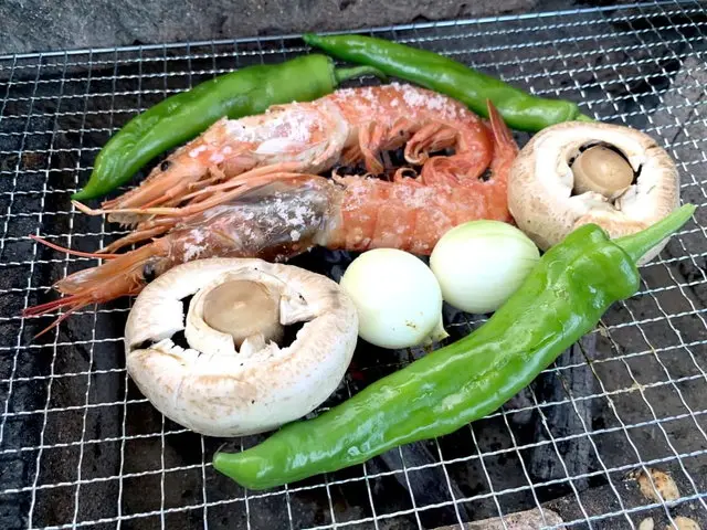 バーベキュー網の上の野菜や海老