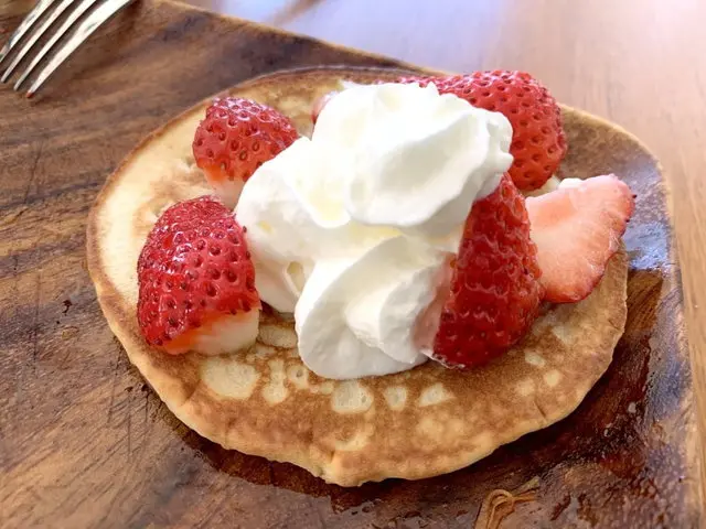 ホイップクリームと苺をのせたパンケーキ