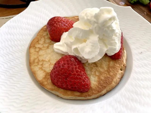 ホイップクリームと苺をのせたパンケーキ