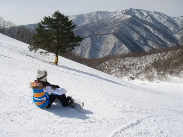 雪山の斜面に座るスノーボーダー